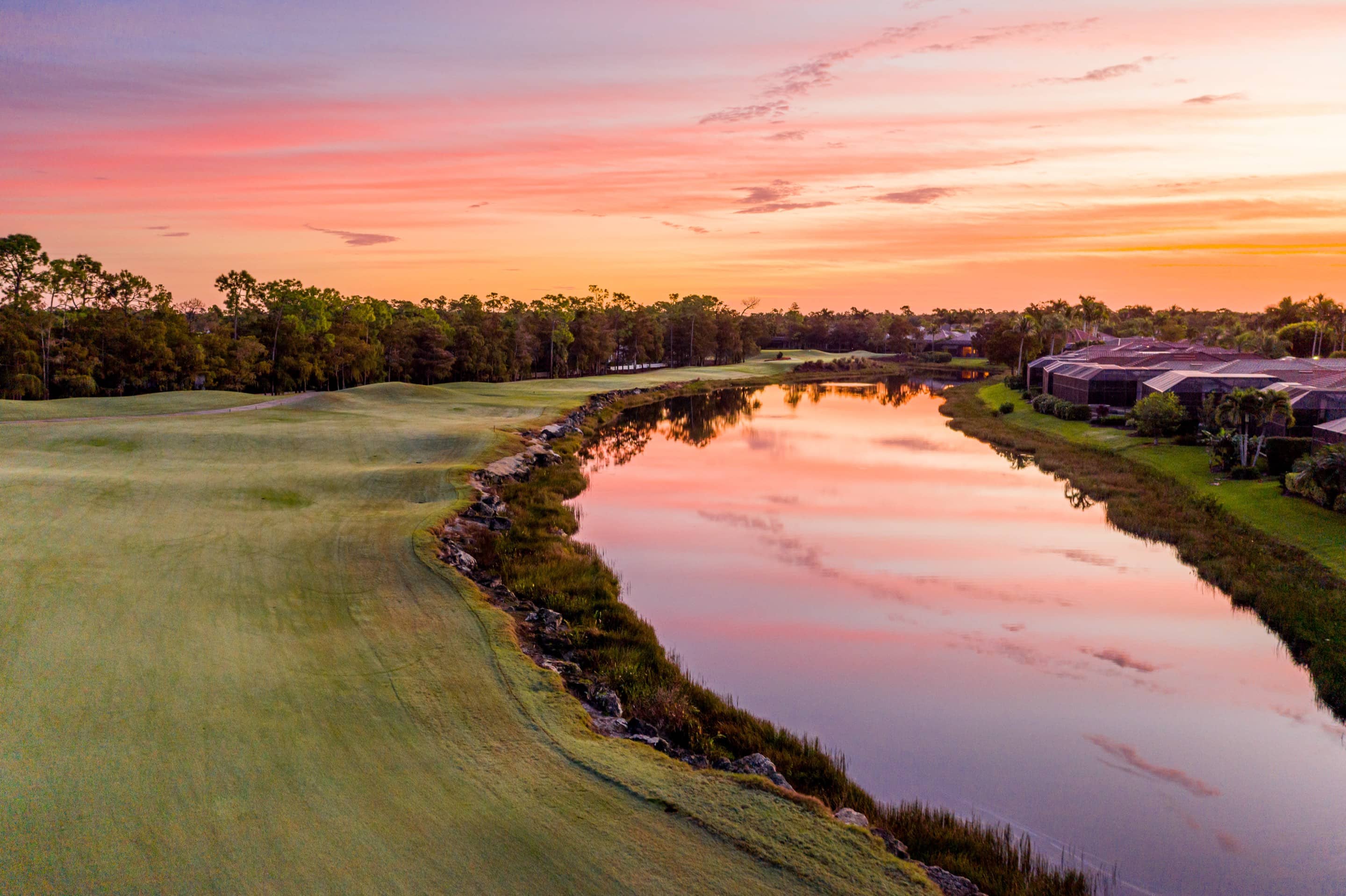 A fairway and lake at Olde Cypress at sunset, with homes across the water