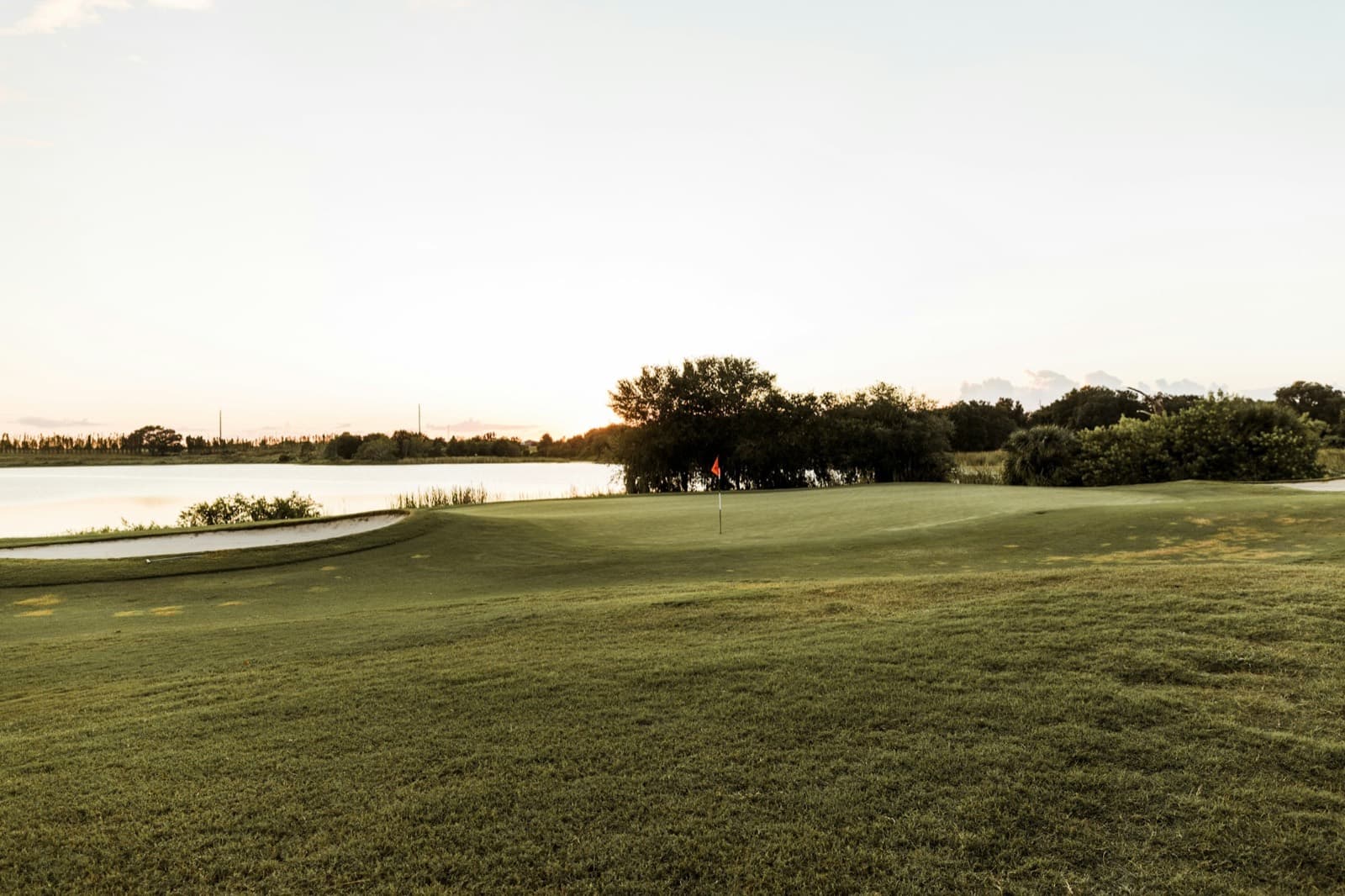 A green beside a lake in the evening light
